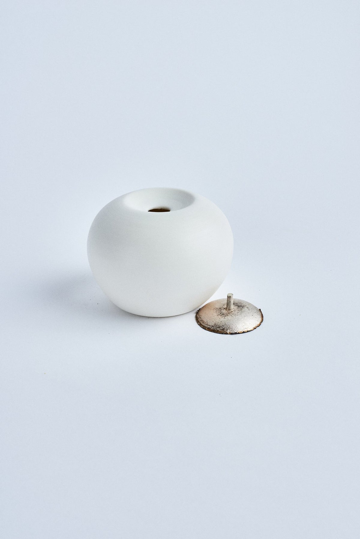 Pandora ouverte, de profil : globe en porcelaine et son couvercle en argent recyclé retourné, avec sa tige